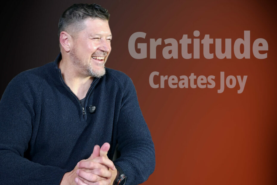 A smiling man against a warm orange gradient background with the text "Gratitude Creates Joy," representing the positive emotional impact of practicing Biblical Gratitude.